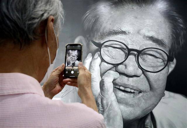 미소 남기고 떠난 국민MC 송해 - ‘진정한 국민MC’ 송해(본명 송복희)가 8일 세상을 떠났다. 향년 95세. 이날 오후 대구 달성군 옥포읍 송해기념관을 찾은 시민들이 송해 선생을 애도하며 환하게 웃는 모습을 휴대전화에 담고 있다. 2022.6.8 뉴스1
