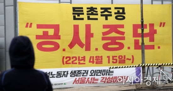 역대 최대 재건축 사업지인 서울 강동구 둔촌주공 재건축단지가 공사 중단 사태에 직면했다. 조합과 시공사 간 사업비를 둘러싼 갈등이 극에 달하면서 둔촌주공 시공사업단(현대건설 등 4개사)은 오는 15일부로 공사 중단을 예고했다. 사진은 14일 재건축 현장에 걸린 공사 중단 현수막./김현민 기자 kimhyun81@