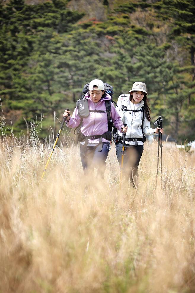 공용기지국으로 이어진 능선의 초원을 걷는 김지영, 오혜진(우측)씨. 오르내림이 꾸준히 이어지지만 100m대 산줄기라 어렵지 않다.