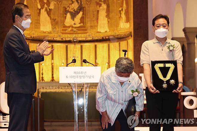 유공자 포상하는 한덕수 총리 (서울=연합뉴스) 김승두 기자 = 한덕수 국무총리가 10일 서울시 중구 대한성공회 서울주교좌성당에서 열린 제35주년 6·10민주항쟁 기념식에 참석, 유공자들을 포상하고 있다. 2022.6.10 kimsdoo@yna.co.kr