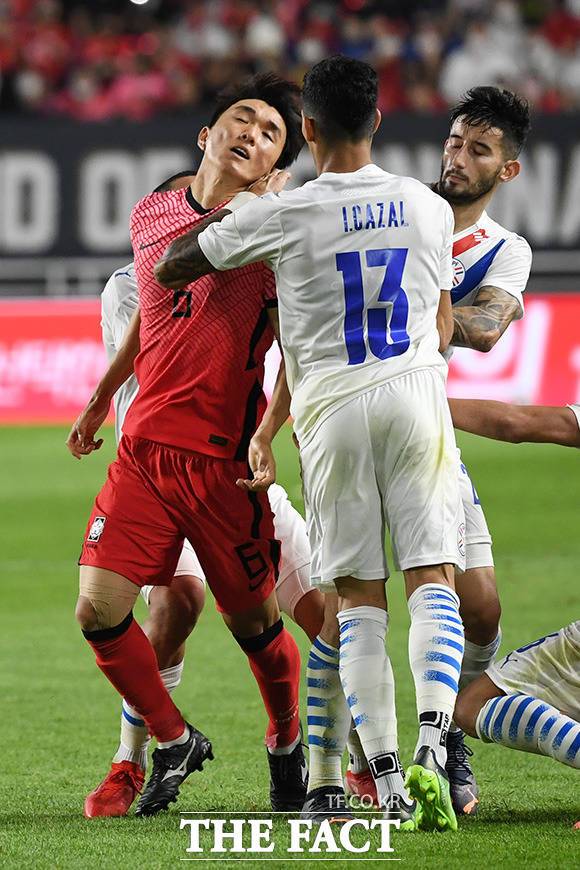 파라과이 선수들에게 밀려나는 황인범.