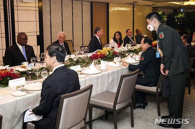 [싱가포르=AP/뉴시스]웨이핑허 중국국방부장(가운데 오른쪽)이 로이드 오스틴 미 국방장관(왼쪽)이 11일(현지시간) 싱가포르 샹그리라 대화 참석중 양자회담을 하고 있다.2022.6.11.