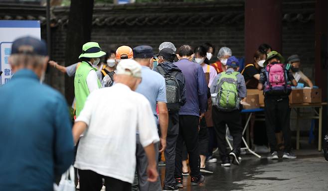 서울 탑골공원에서 어르신들이 무료급식을 기다리고 있다./연합뉴스