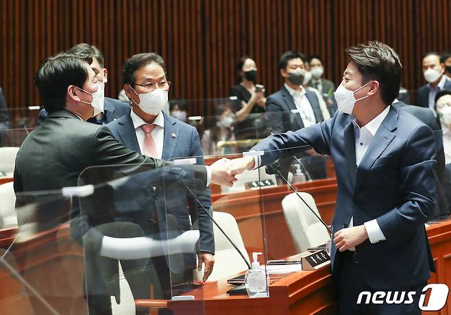 이준석 국민의힘 대표(오른쪽)와 안철수 의원이 14일 오후 서울 여의도 국회에서 열린 의원총회에서 악수하고 있다. (공동취재) 2022.6.14/뉴스1 © News1 이재명 기자