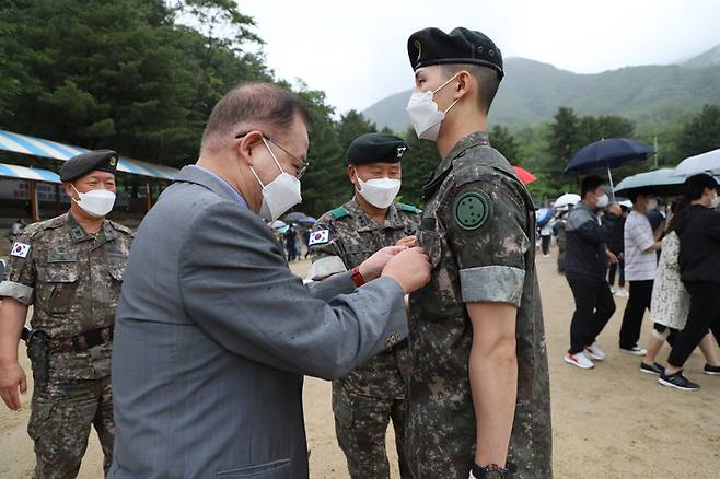 [화천=뉴시스] 김경목 기자 = 15일 오전 강원 화천군 육군 제7보병사단(칠성부대) 연병장에서 코로나19 거리두기 완화 후 2년 6개월 만에 가족·친지들이 참석 가능한 대면 신병 수료식이 열렸다. 예비역 육군 대령인 정해천씨가 아들 정영욱 이등병에게 계급장을 달아주고 있다. (사진=육군 제7보병사단 제공) 2022.06.15. photo@newsis.com *재판매 및 DB 금지