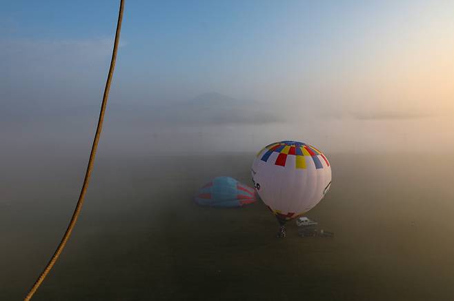 안개 낀 아침 이륙을 준비하는 열기구들 [사진/진성철 기자]