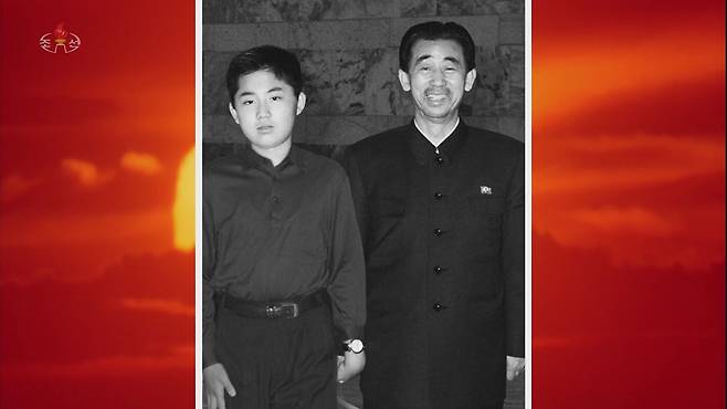 북한 조선중앙TV는 지난 12일 밤 김정일 정권의 군부 핵심인물이자 김정은 국무위원장의 후계교육을 맡았던 현철해 국방성 총고문의 생애를 다룬 기록영화 '빛나는 삶의 품: 태양의 가장 가까이에서'를 공개했다. 사진은 영화에서 공개된 어린 시절 김정은(왼쪽)과 그의 곁에 서있는 현철해의 모습. /조선중앙TV·연합뉴스