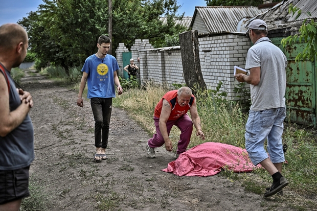 아버지의 날을 하루 앞둔 18일(이하 현지시간) 우크라이나 동부 루한스크주 리시찬스크에서 한 아버지가 러시아군 집속탄 공격에 숨진 아들의 시신 앞에 주저 앉고 있다./출처=AFP 연합뉴스