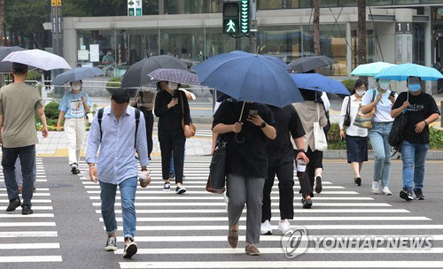 전국적인 장마 시작이 예보된 23일 오전 시민들이 서울 중구 을지로입구역 인근에서 우산을 쓰고 횡단보도를 건너고 있다. <연합뉴스>