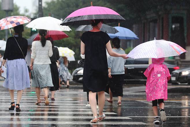 23일 오후 서울 종로구 광화문 네거리 일대에서 한 어머니가 자녀의 우산을 잡아주고 있다. 백소아 기자