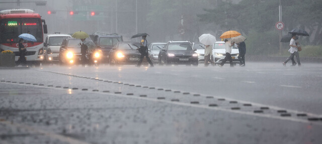 서울·인천·경기 지역에 호우주의보가 내려진 23일 오후 서울 여의대로에서 시민들이 우산을 쓴 채 걸어가고 있다. 연합뉴스