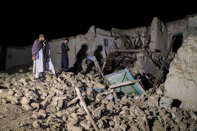 아프가니스탄 파크티카주의 가얀에서 22일(현지시간) 지진으로 무너진 집 주변을 탈레반 당국과 구호 활동가들이 둘러보고 있다. EPA연합뉴스