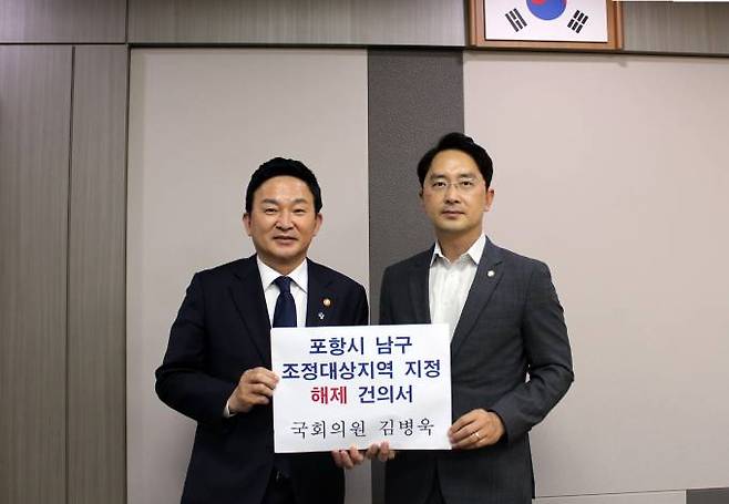 김병욱 의원(오른쪽)이 원희룡 국토부 장관에게 포항 남구 조정 대상 지역 해제 건의서를 전달하고 있다. (의원실 제공) 2022.06.23