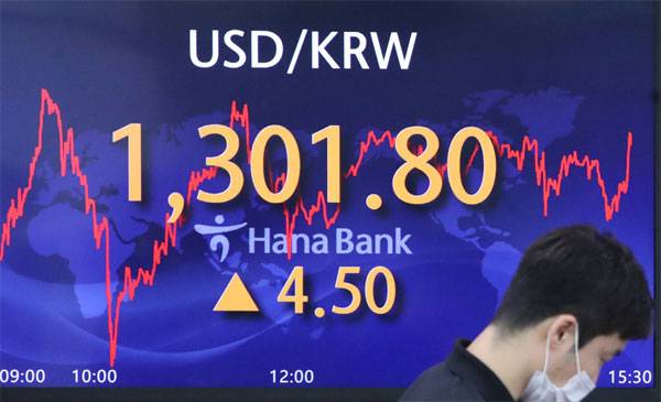 23일 달러당 원화값이 1301.8원으로 마감하며 글로벌 금융위기 이후 약 13년 만에 최저치를 기록했다. 서울 하나은행 본점 딜링룸 앞을 한 직원이 지나가고 있다.  [김호영 기자]