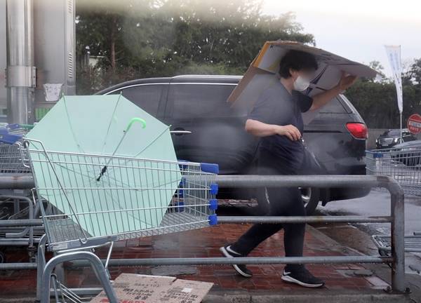 목요일부터 전국적으로 장마가 시작돼 시간당 최대 50㎜의 많은 비가 내릴 것으로 예상된다. 주말에는 어느 정도 장마가 잦아들겠으나 더운 날씨가 이어질 전망이다. 사진은 지난 10일 서울 한 대형마트 앞에서 박스를 이용해 비를 피하는 시민. /사진=뉴스1