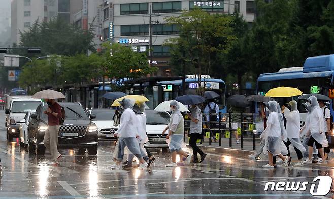 장맛비가 내리는 지난 23일 오후 서울 세종대로사거리 횡단보도에서 우산을 쓰고 우비를 입은 시민들이 발걸음을 재촉하고 있다. 2022.6.23/뉴스1 © News1 박세연 기자