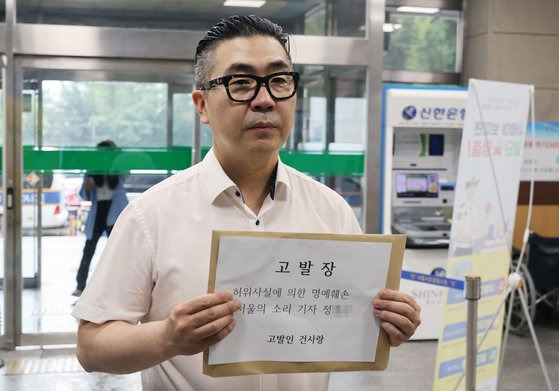 김건희 여사 팬카페인 '건사랑' 관계자가 23일 오후 윤석열 대통령 서초동 자택 앞에서 맞불 집회를 벌여온 인터넷 언론사 '서울의소리'의 정 모 기자를 허위사실에 의한 명예훼손 혐의로 서울 서초경찰서에 고발하고 있다. 연합뉴스