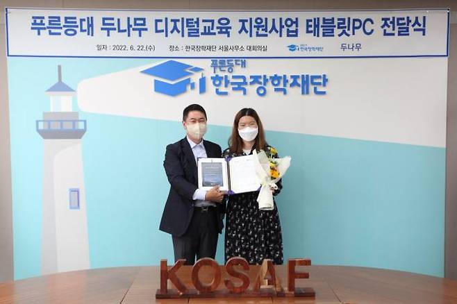 지난 22일 한국장학재단 서울사무소에서 진행된 ‘푸른등대 두나무 디지털교육 지원사업 태블릿PC 전달식’에서 이석우 두나무 대표이사(왼쪽)가 장학증서와 디지털기기를 전달하며 기념촬영을 하고 있다. 두나무 제공