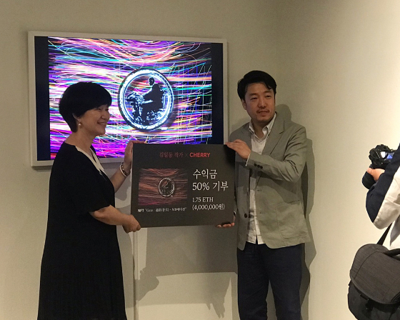 팝 아티스트 김일동 작가(사진 오른쪽)가 NFT 작품 판매 수익의 50%를 기부하면서 이수정 이포넷 대표와 기념 촬영 중이다/사진제공=이포넷