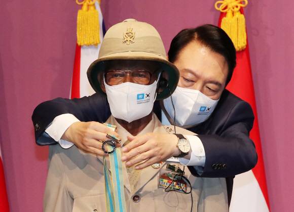 윤석열 대통령이 6?25전쟁 72주년을 하루 앞둔 24일 서울 중구 신라호텔 다이너스티홀에서 열린 국군 및 유엔군 참전유공자 위로연에서 에티오피아 참전용사 테페라 네구시 모루 씨에게 ‘평화의 사도’ 메달을 직접 걸어주고 있다. 2022.6.24 대통령실사진기자단