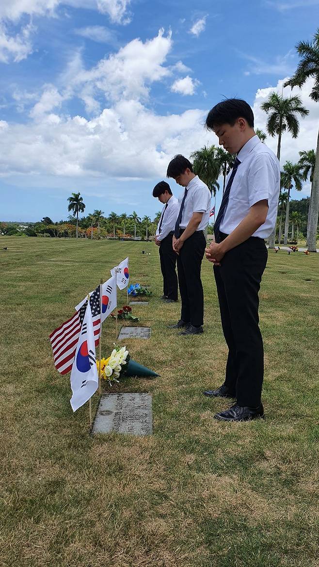 IYF 굿뉴스코 푸에르토리코 해외봉사단원들이 지난 24일(현지 시각) 푸에르토리코 바야몬시 국립묘지를 찾아 6·25 참전용사들의 묘지 앞에 서서 이들을 추모하고 있다./IYF 굿뉴스코 푸에르토리코 해외봉사단