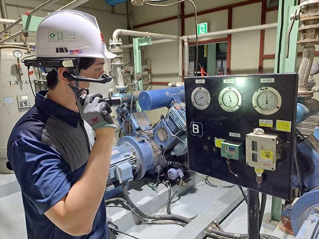 한국지역난방공사 한 작업자가 지능형 영상 헬멧을 쓴 채 현장 설비를 점검하고 있다. (사진=지역난방공사)