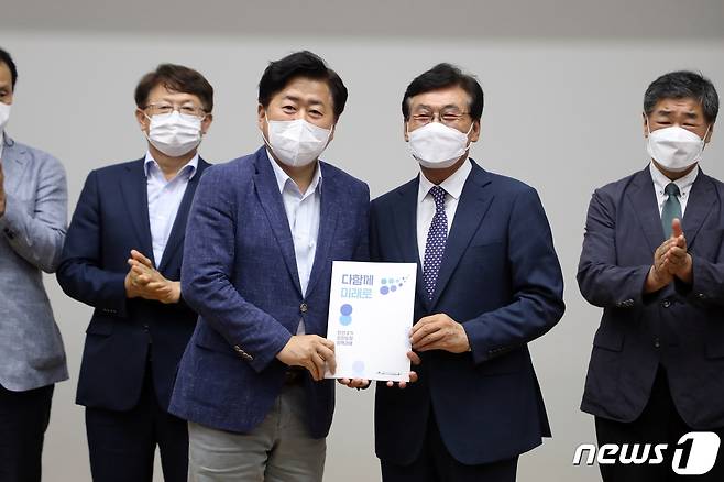 오영훈 제주도지사 당선인(왼쪽)이 28일 제주웰컴센터 웰컴홀에서 송석언 인수위원장으로부터 다함께 미래로 준비위원회의 ‘민선 8기 도민도정 비전 및 도정과제 보고서’를 전달받고 있다.2022.6.28/뉴스1 © News1 홍수영 기자