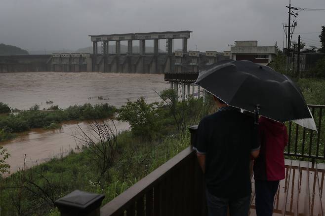 장마전선 영향으로 북한 지역에 집중호우가 지속되는 가운데 28일 경기도 연천군 군남홍수조절댐에서 주민들이 방류되는 임진강 상류의 물을 바라보고 있다. /연합뉴스