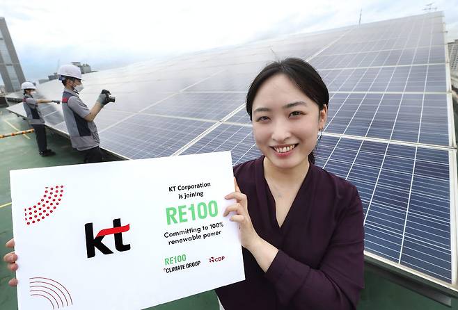 KT구로타워 옥상에 구축된 태양광발전소에서 KT 직원이 RE100 가입을 알리고 있다.