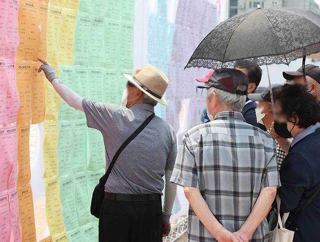 지난 21일 오후 경기도 수원시 화성행궁 광장에서 열린 ‘제11회 수원시 노인 일자리 채용한마당’에서 노인들이 채용 정보 게시판을 살펴보고 있다. 연합뉴스