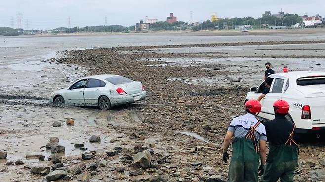 [인천=뉴시스] 이루비 기자 = 28일 인천 옹진군 선재도 갯벌에 빠진 승용차를 소방당국과 해경이 공동대응해 견인하고 있다. (사진=인천소방본부 제공) 2022.06.28. photo@newsis.com *재판매 및 DB 금지