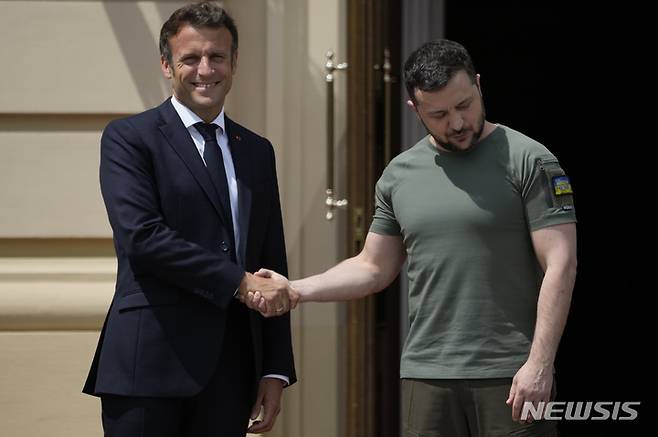 [키이우=AP/뉴시스] 볼로디미르 젤렌스키(오른쪽) 우크라이나 대통령과 에마뉘엘 마크롱 프랑스 대통령이 16일(현지시간) 키이우 마리인스키궁에서 악수하고 있다. 우크라이나를 방문한 프랑스·독일·이탈리아·루마니아 정상은 이날 기자회견에서 우크라이나의 유럽연합(EU) 가입 후보국 지위를 지지한다고 밝혔다. 2022.06.17.