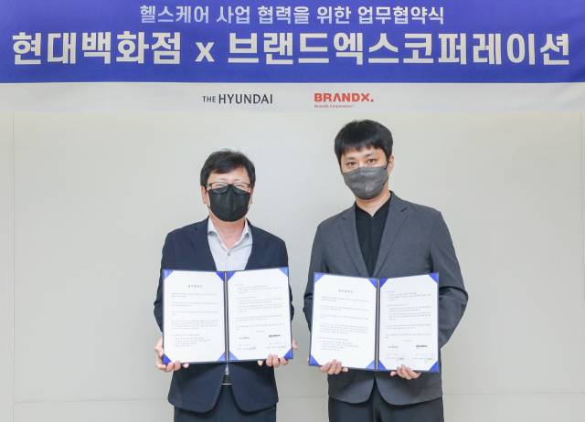 박채훈(왼쪽) 현대백화점 미래사업부 사업부장과 박희종 브랜드엑스코퍼레이션 부대표가 28일 오전 서울 강남구 현대백화점그룹 본사 사옥에서 업무협약 체결 후 기념 촬영을 하고 있다./사진 제공=현대백화점