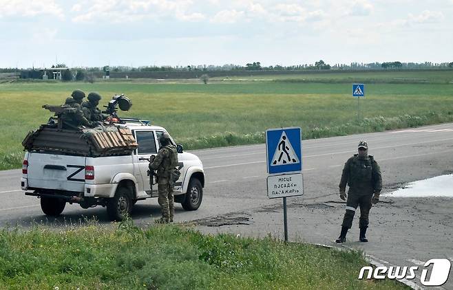 19일(현지시간) 러시아 군이 점령한 우크라이나 헤르손의 도로에서 병사가 군용 트럭을 타고 순찰을 하고 있다. © AFP=뉴스1 © News1 우동명 기자