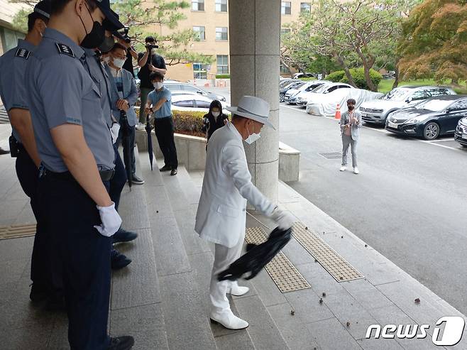 오천도 애국국민운동연합 대표가 지난 14일 충북도의회 현관에서 도의원들의 외유성 몽골 견학을 중단하라면서 오물을 투척하고 있다./뉴스1 © News1 엄기찬 기자