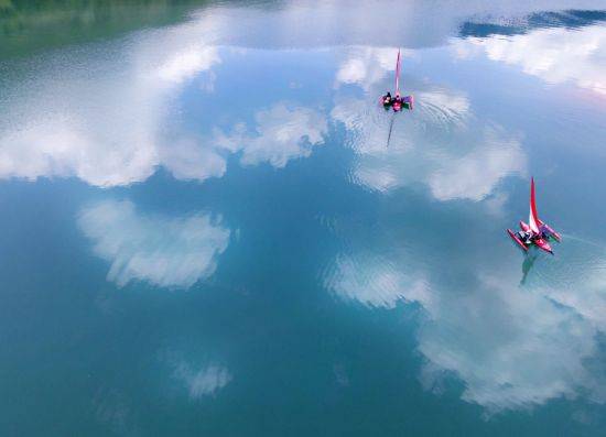 구름과 파란 하늘을 품은 파로호의 맑은 수면위로 세일링카약이 유유히 미끄러지고 있다
