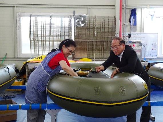 이희재 우성아이비 대표(오른쪽)가 보트 작업을 하고 있는 직원에게 꼼꼼한 마무리 작업을 지시하고 있다.