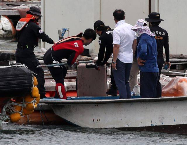 28일 오후 전남 완도군 신지면 송곡선착장 방파제로부터 80m 지점 가두리 양식장 아래에서 실종된 조유나(10) 양 가족 차량인 아우디 승용차가 발견됐다. 경찰이 수중에 있는 차량 내에서 케리어를 건져 올리고 있다. 연합뉴스
