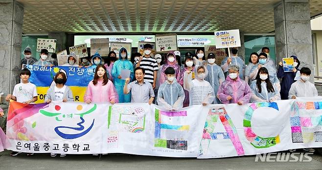 [진천=뉴시스] 강신욱 기자 = 충북 진천 은여울중고등학교 학생 30여 명이 송기섭 진천군수와 함께 29일 진천군청 현관에서 우크라이나 전쟁 참상을 알리고 인류의 평화에 관심을 촉구하는 거리 캠페인에 앞서 구호를 외치고 있다. 2022.06.29. ksw64@newsis.com