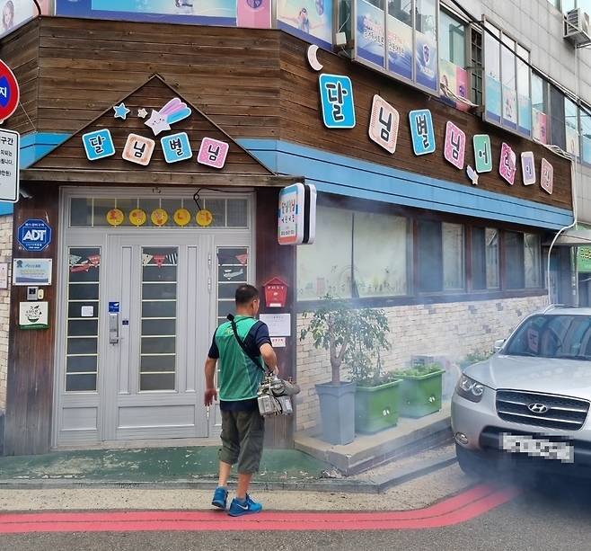 새마을 방역봉사대 관계자가 어린이집 주변에서 방역 활동을 하고 있다.강서구 제공