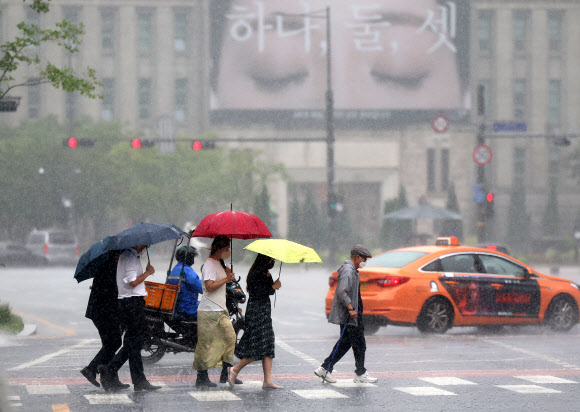 호우주의보 발효된 서울 - 서울지역에 장맛비가 내린 29일 오후 서울도서관 인근에서 시민들이 우산을 쓴 채 횡단보도를 건너고 있다. 2022.6.29 연합뉴스