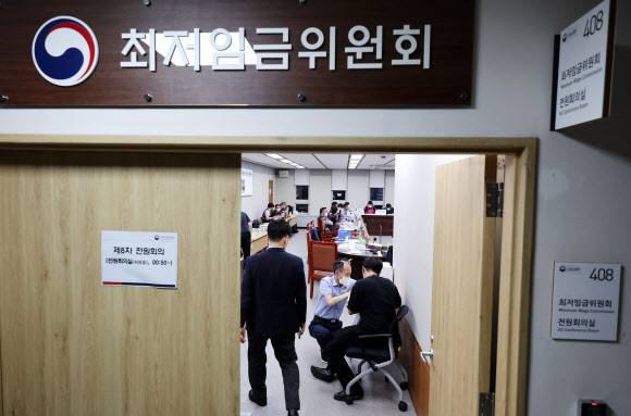 다시 개회되는 전원회의 - 29일 오후 세종시 정부세종청사 최저임금위원회 회의실에서 열린 제8차 전원회의가 휴정을 마친 뒤 시작해 사용자위원, 근로자 위원, 공익위원들이 자리로 향하고 있다. 2022.6.29 연합뉴스
