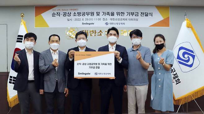 기부금 전달식에 참여한 대한소방공제회 이형선 회원복지팀장(왼쪽부터), 최봉갑 회원지원부장, 이형철 이사장, 스마일게이트 메가포트 정재훈 이사, 김건욱 팀장, 희망스튜디오 권연주 실장이 사진을 촬영하고 있다. (사진=스마일게이트)