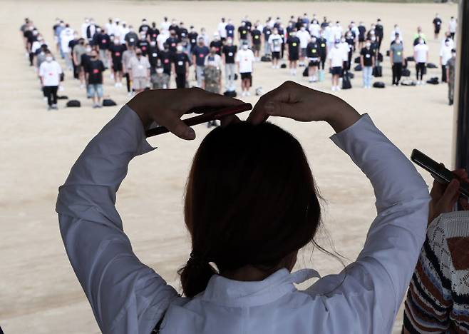 20일 오후 강원 화천군 육군15사단 신병교육대대에서 열린 입영식에서 장병 가족이 입영하는 아들을 향해 팔로 하트를 보내고 있다.(사진=연합뉴스)