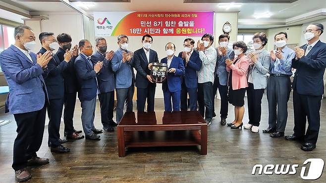 조규선 서산시장직 인수위원장이 30일 제11대 이완섭 서산시장 당선인에게  '시민행복, 서산발전 화수분'을 전달하는 모습(중앙 좌측 이완섭 당선인, 우측 조규선 위원장)© 뉴스1