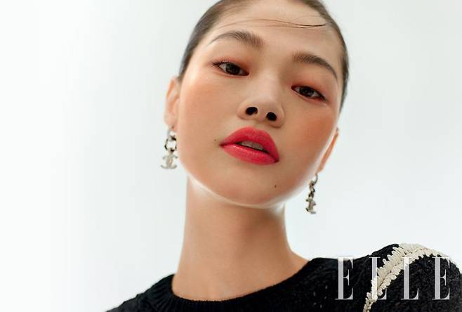 말갛게 윤기 어린 피부 위에서 선명하게 빛나는 래디언스 피니쉬의 입술이 투명한 느낌을 배가한다. N°1 DE CHANEL 레드 까멜리아 립 앤 치크 밤, 2 헬시 핑크를 눈가와 볼에 얹어 생기를 더하고, 루쥬 알뤼르 렉스트레, 844를 립 라인 넘어까지 도톰하게 채워 바른다. 바움 에쌍씨엘 글로우 스틱, 트렌스페어런트를 광대뼈와 콧등, 이마, 턱 끝에 덧바르면 물기 어린 광채 피부 완성. 사용 제품은 모두 Chanel.톱과 이어링은 모두 Chanel.