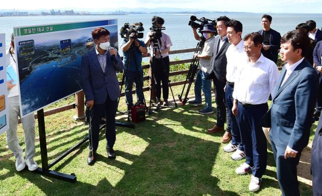 이준석 국민의힘 대표가 29일 오후 경북 포항시 남구 동해면 연오랑세오녀 테마공원에서 포항시 관계자에게 영일만 대교 사업 추진 경과에 대해 설명을 듣고 있다. 포항=뉴시스