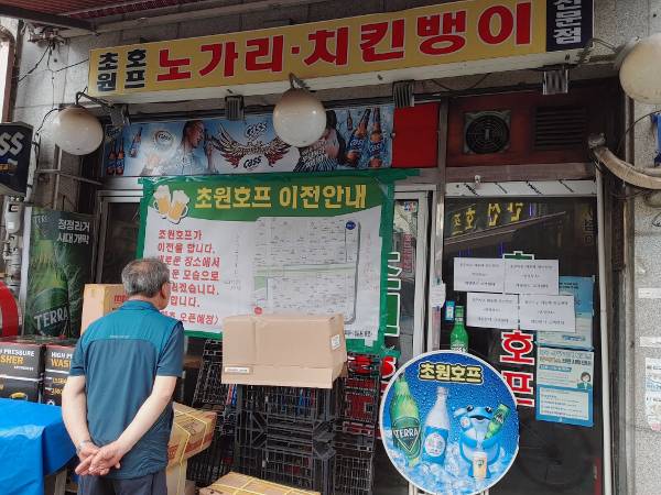 29일 오후 서울 중구 을지로 노가리 골목의 옛 초원호프 매장을 찾은 손님이 매장 이전을 알리는 안내문을 들여다보고 있다.