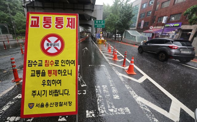 서울 잠수교 북단에서 경찰이 한강 수위 상승으로 차량 출입을 통제하고 있다. 연합뉴스