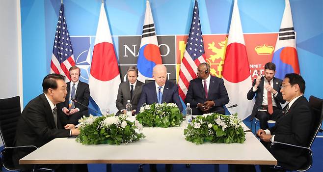 윤석열 대통령(왼쪽)이 29일(현지시간) 스페인 마드리드 이페마(IFEMA) 국제회의장에서 열린 한·미·일 정상회의에 참석해 조 바이든 미국 대통령(가운데), 기시다 후미오 일본 총리(오른쪽)와 대화하고 있다. [마드리드 = 이승환 기자]